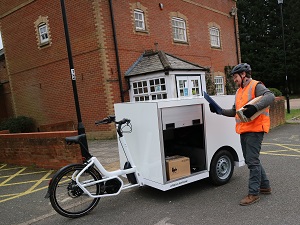 Man delivering parcels with cargo bike opening at the side