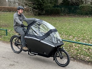 Man riding an e-cargo bike with a child area at the front