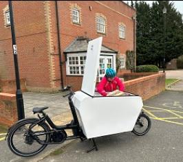A person unpacking a business e-cargo deliver bike